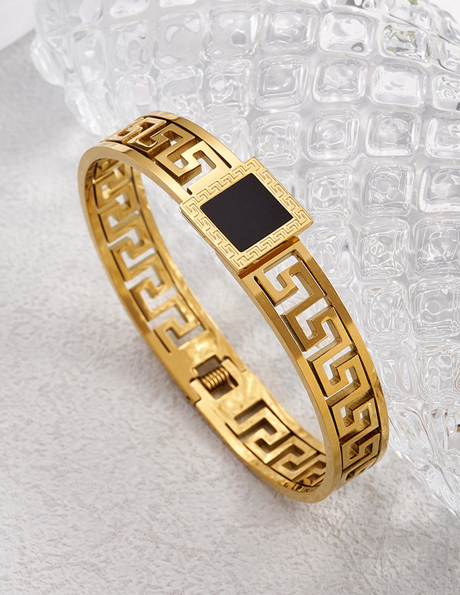 Brazalete rígido de oro laminado con diseño de grecas